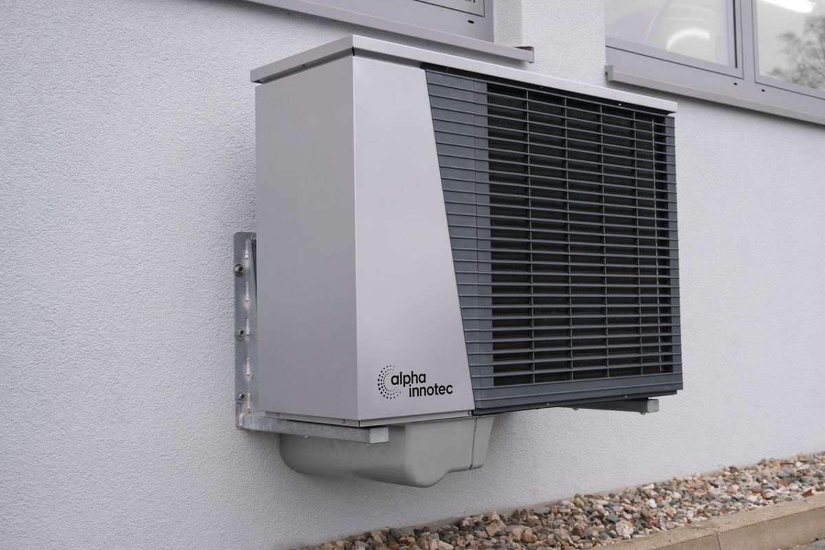Wall-mounted ductless mini-split outdoor unit on a house exterior