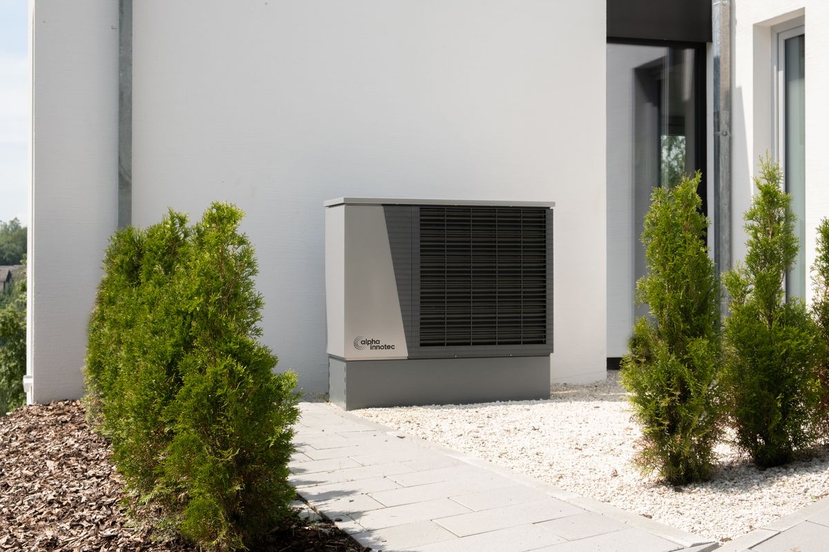 Outdoor heat pump unit installed alongside a residential home