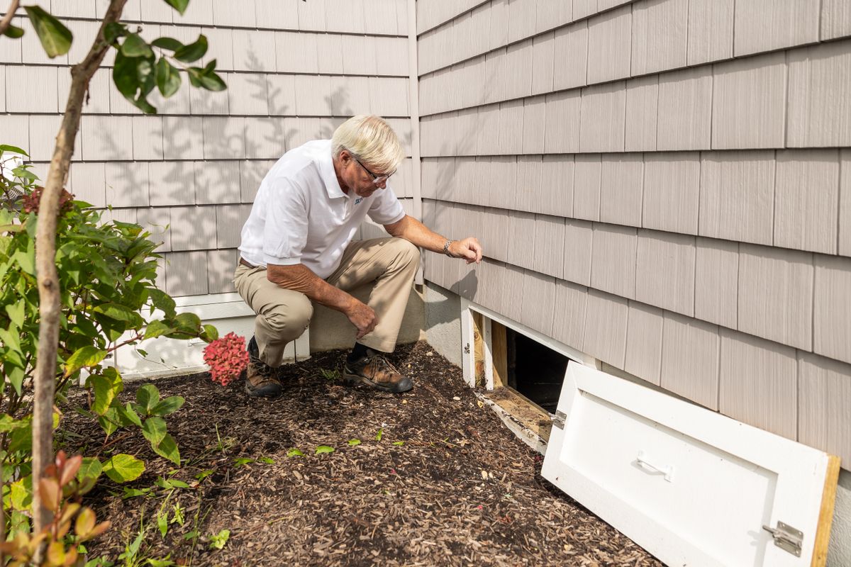 Technician inspecting a home during a seasonal maintenance visit