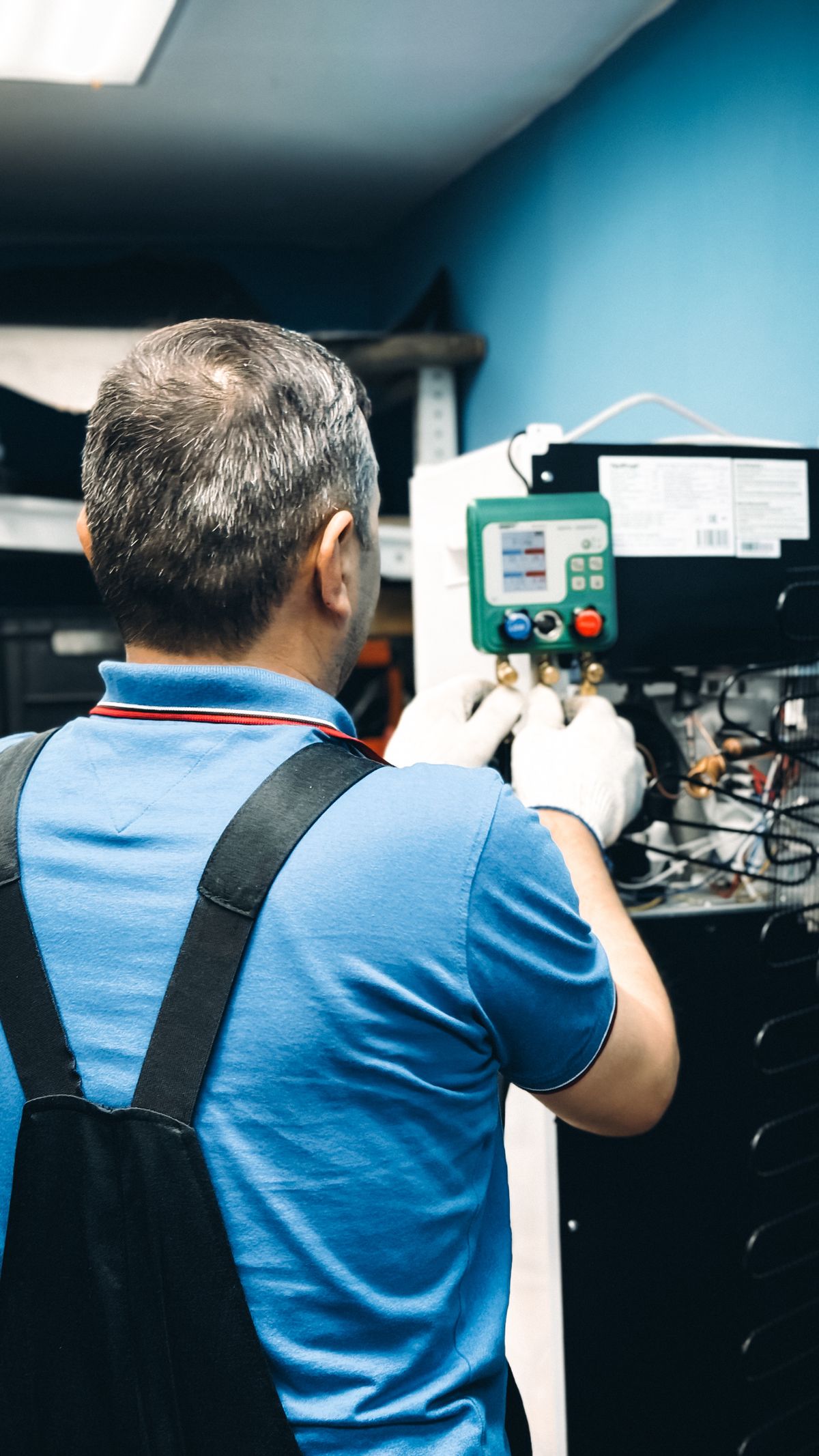 HVAC technician using manifold gauges to diagnose a heating system